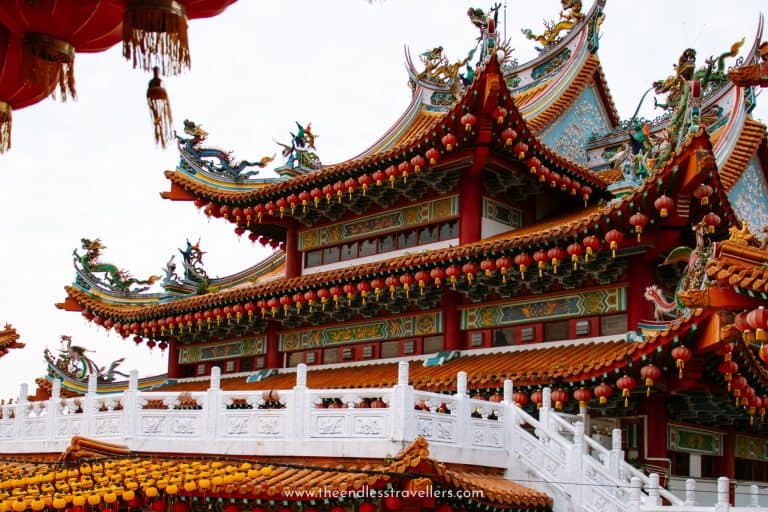 Colorful close-up of the ornate Thean Hou Temple featuring detailed dragon sculptures and traditional Chinese architectural elements decorated with red lanterns.